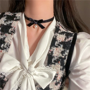 Detail shot of vintage black velvet choker with bow knot and elegant pearl pendant