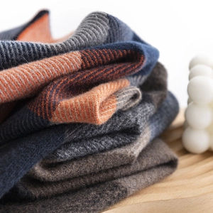 Stack of ribbed knit men's cashmere-like scarves in navy, orange and brown colors