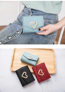 Detailed view of women's tri-fold wallets with heart-shaped metal buckles in three colors