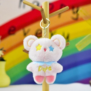 Gros plan d'un adorable porte-clés ours en peluche rose avec des yeux en étoile