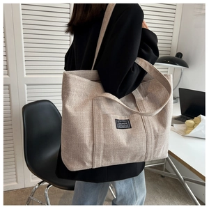 Close-up of the large canvas tote bag with fashion label shown in a lifestyle setting