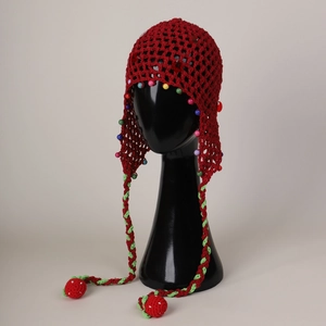 Detail of red hollow knit beanie with colorful beads and hanging strawberry tassels