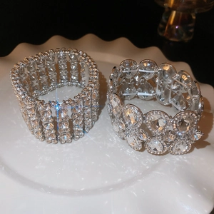 Close-up of wide silver bangles with sparkling teardrop crystals and pavé rhinestones