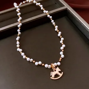 Elegant gold-plated pearl necklace featuring a classic rocking horse pendant in a jewelry box