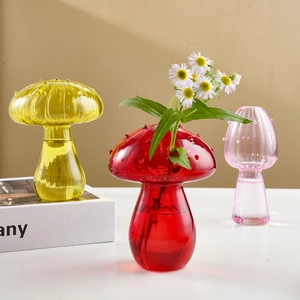 Three colorful mushroom-shaped glass vases for flowers in red, yellow, and pink colors