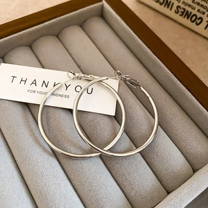 Irregular silver hoop earrings for women displayed in a velvet jewelry box