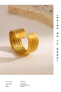 Detail shot of golden wide band ring with tree bark texture and adjustable open design