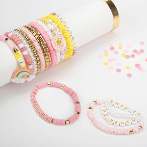 Détail de bracelets DIY en perles Heishi roses et bleues avec lettres et breloques