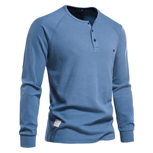 Détail du tissu gaufré bleu et de la patte de boutonnage d'un t-shirt Henley homme