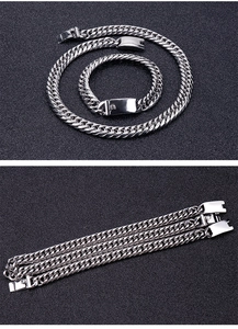 Detailed view of silver stainless steel Cuban link necklace and bracelet set with square clasp