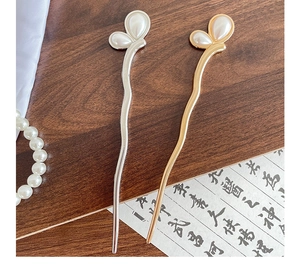 Detailed close-up of gold and silver butterfly hair pins with elegant pearl inlay