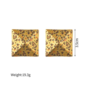 Detail view of square leopard print earrings with gold tone finish, 3.5cm size