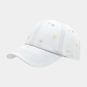 Detailed close-up of daisy embroidery on light blue denim washed baseball cap fabric