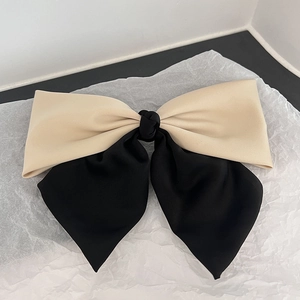 French style two-tone beige and black fabric bow spring clip on white background