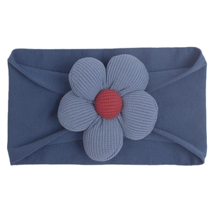 Detail of navy blue knitted baby headband featuring a textured floral design with red center