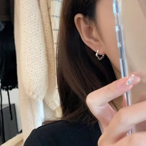 Minimalist s925 silver heart shaped hoop earrings worn by a model in a lifestyle setting