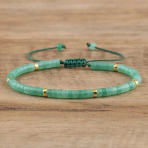 Close-up of adjustable hand-woven green natural stone bracelet with gold metal spacers