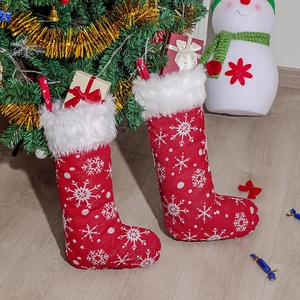 Christmas stocking with white snowflake embroidery and plush faux fur trim by a tree