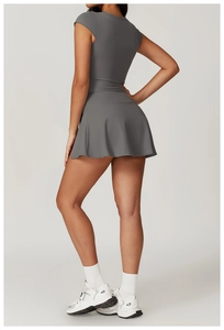Detail view of charcoal gray slim-fit sports top and pleated athletic tennis skirt set