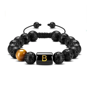 Detailed texture of black lava rock and tiger eye beads with letter B charm
