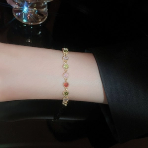Close-up of gold plated tennis bracelet with colorful round cut zircon gemstones