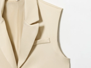 Détail d'un gilet en sergé blanc crème avec col à revers et coutures de poche précises