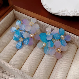 Boucles d'oreilles fleurs en résine bleue et violette avec perles dans un coffret bois