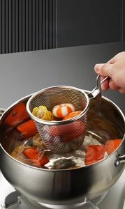 Detail of 304 stainless steel mesh skimmer with hook handle used for boiling meat and veggies