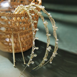 Detail of three golden leaf headbands with faux pearls and cat eye stone flower accents