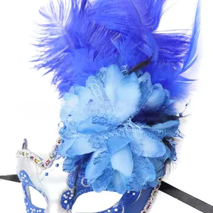 Dettaglio di piume blu, fiori in organza e brillantini argento sulla maschera da ballo