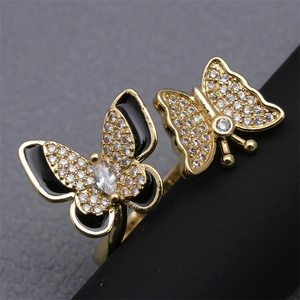 Macro view of double butterfly ring with gold plating, white crystals and black enamel