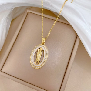 Gros plan d'un pendentif portrait religieux en or avec nacre et diamants dans un coffret