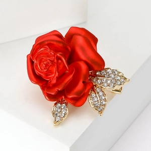 Exquisite red rose brooch with golden rhinestone leaves on minimalist white stage