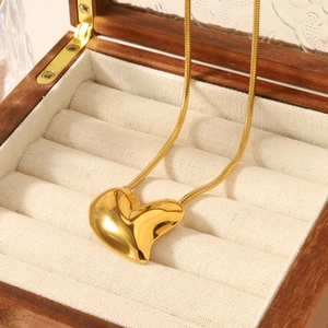 Polished 18k gold minimalist 3D heart pendant necklace on a wooden jewelry box