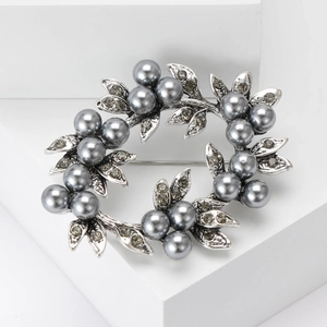 Detailed view of silver wreath brooch with grey pearls and sparkling rhinestones