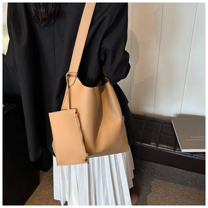 Detail of camel leather tote bag with wide shoulder strap and matching mini pouch