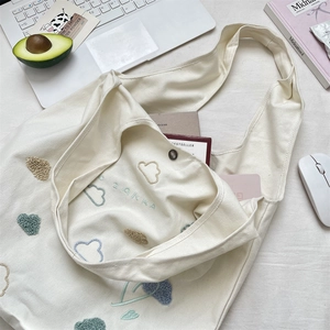 Detail of embroidered cloud canvas tote bag featuring magnetic closure and inner ZAKKA text