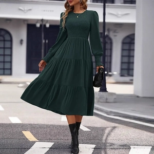 Detailed view of the smocked bodice and ruffled cuffs on this dark green tiered dress