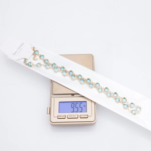 Detailed macro shot of 9.55g gold plated heart crystal chain on a digital scale