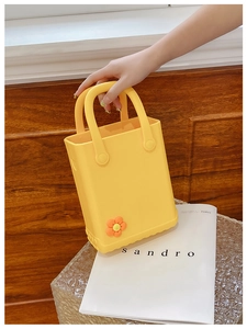 Detail der gelben EVA Strandtasche mit süßem orangefarbenem Blumendekor und Rundgriff