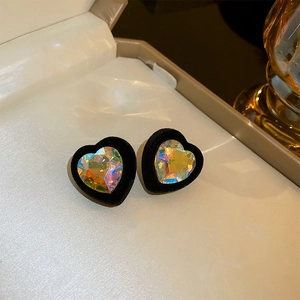 Macro shot of heart-shaped earrings with black velvet trim and faceted crystal centers