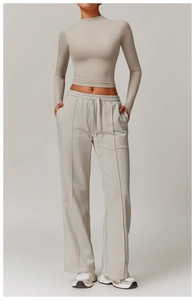 Detail of high-waist loose sweatpants with side pockets and cropped mock neck top