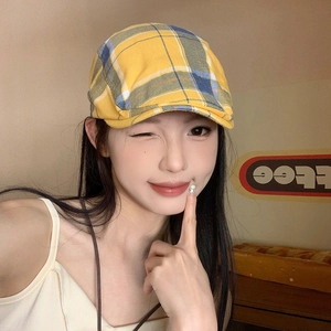 Detailed view of yellow plaid beret hat with textured fabric and classic check pattern