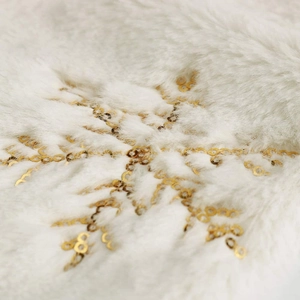 Close-up of white faux fur Christmas stocking with sparkling gold sequin snowflake details