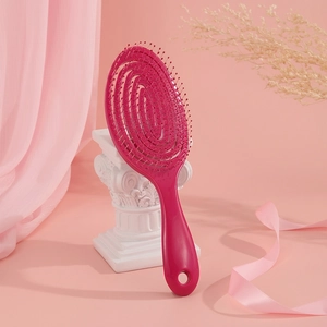 Rose pink vented hair brush for scalp massage and styling on elegant pink background