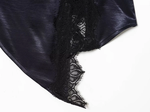 Close-up of deep blue satin fabric with intricate black lace trim and hollowed pattern