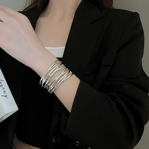 Close-up of minimalist silver multi-layer stacked wire bangle worn by a model