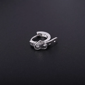 Detail view of silver heart buckle earring with sleek belt design on black background