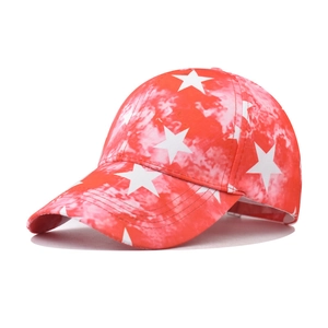 Detail of red tie-dye baseball cap with large white star prints and curved brim