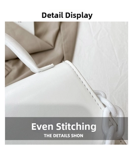 Close-up of fine stitching details and resin chain handle on the white leather handbag